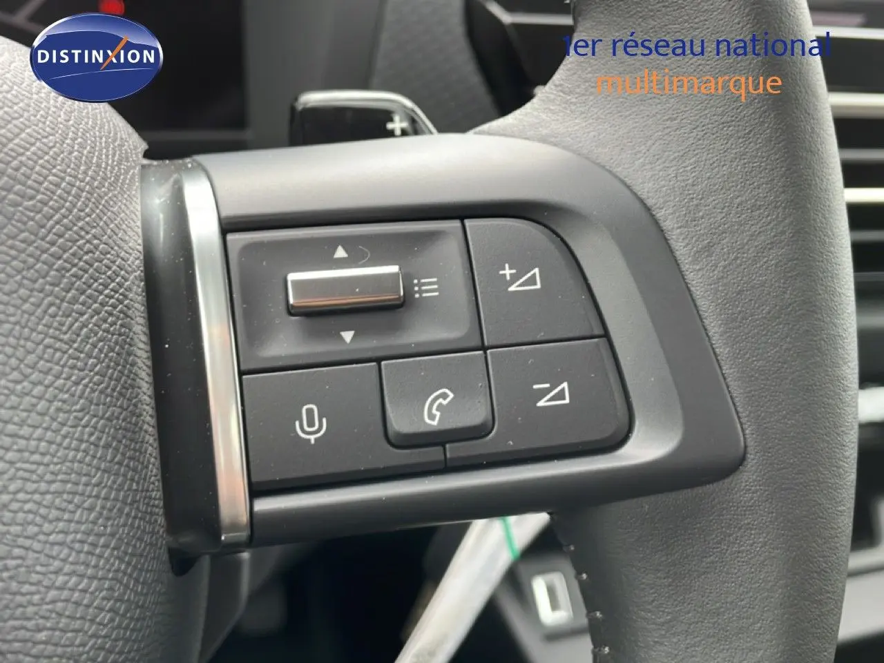 Gros plan sur les commandes au volant noir d'une Citroën C4 blanche métal, version PureTech 130ch EAT8 Plus, 2026.