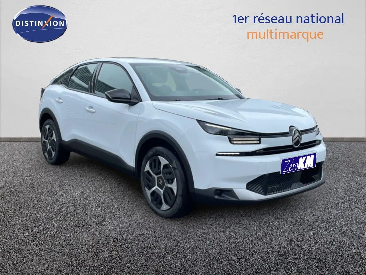 Vue 3/4 avant d'une Citroën C4 blanche métal 2026 avec jantes originales et calandre distinctive.