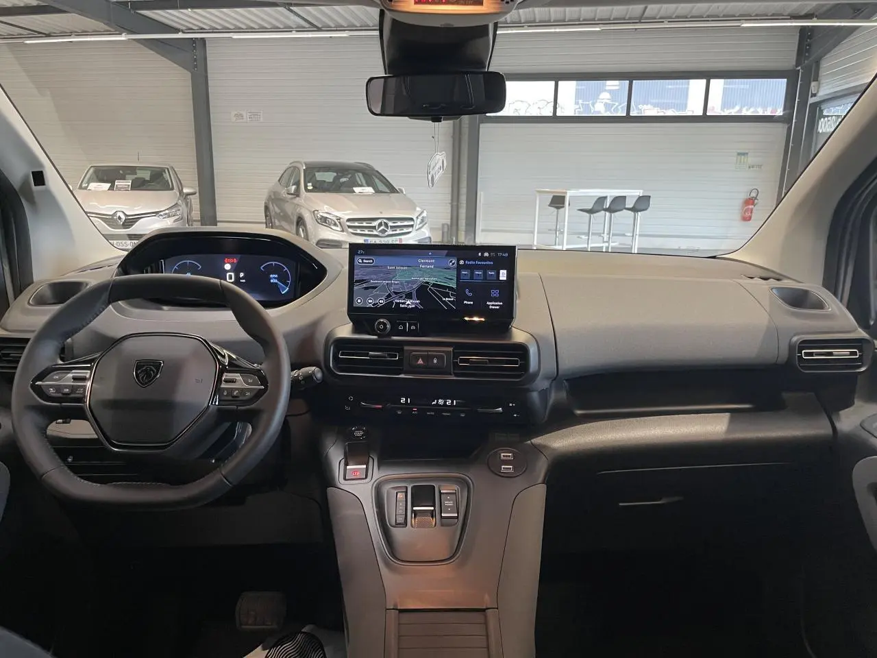 Vue intérieure avant du Peugeot Rifter gris Artense 2026, avec tableau de bord numérique et écran tactile central.