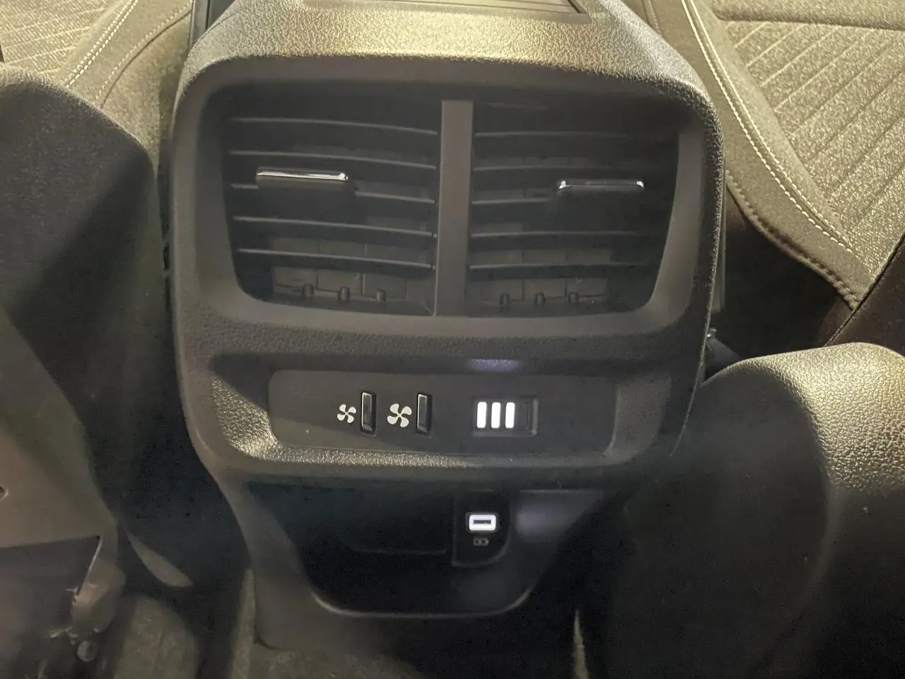 Vue rapprochée des commandes de ventilation arrière et port USB Type-C du Peugeot Rifter gris Artense 2026.