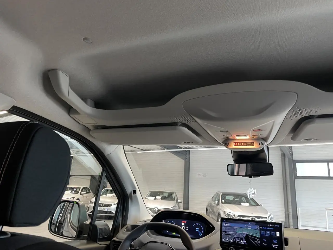 Vue intérieure avant du Peugeot Rifter 2026, tableau de bord numérique et écran tactile avec volant cuir multifonction.