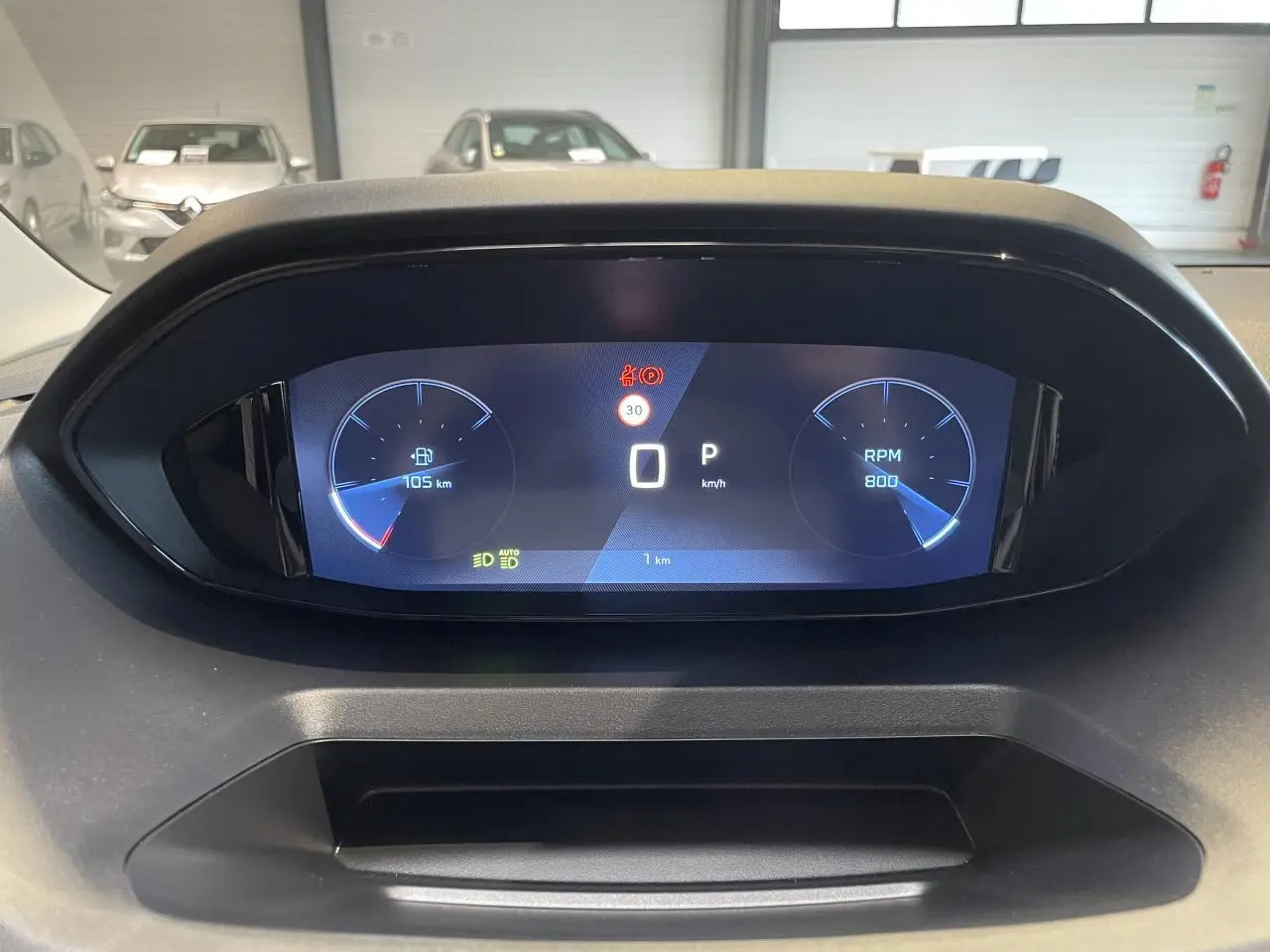 Affichage numérique du combiné de bord du Peugeot Rifter 2026, indiquant vitesse, RPM et autonomie, vue de face.