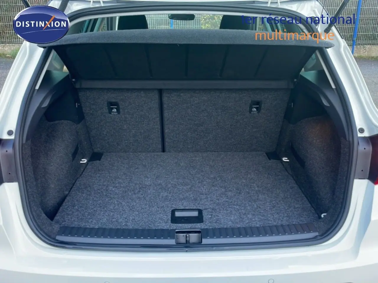 Coffre ouvert d’un SEAT Arona blanc avec toit gris, vue arrière montrant l’espace de chargement vide.