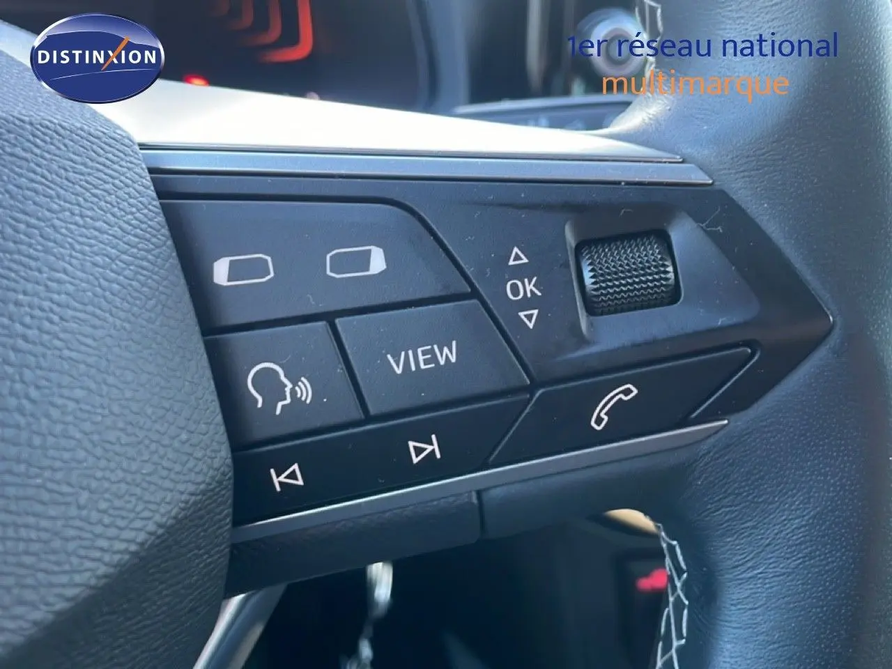 Gros plan sur les commandes multifonctions à droite du volant du SEAT Arona blanc toit gris, édition 2025.