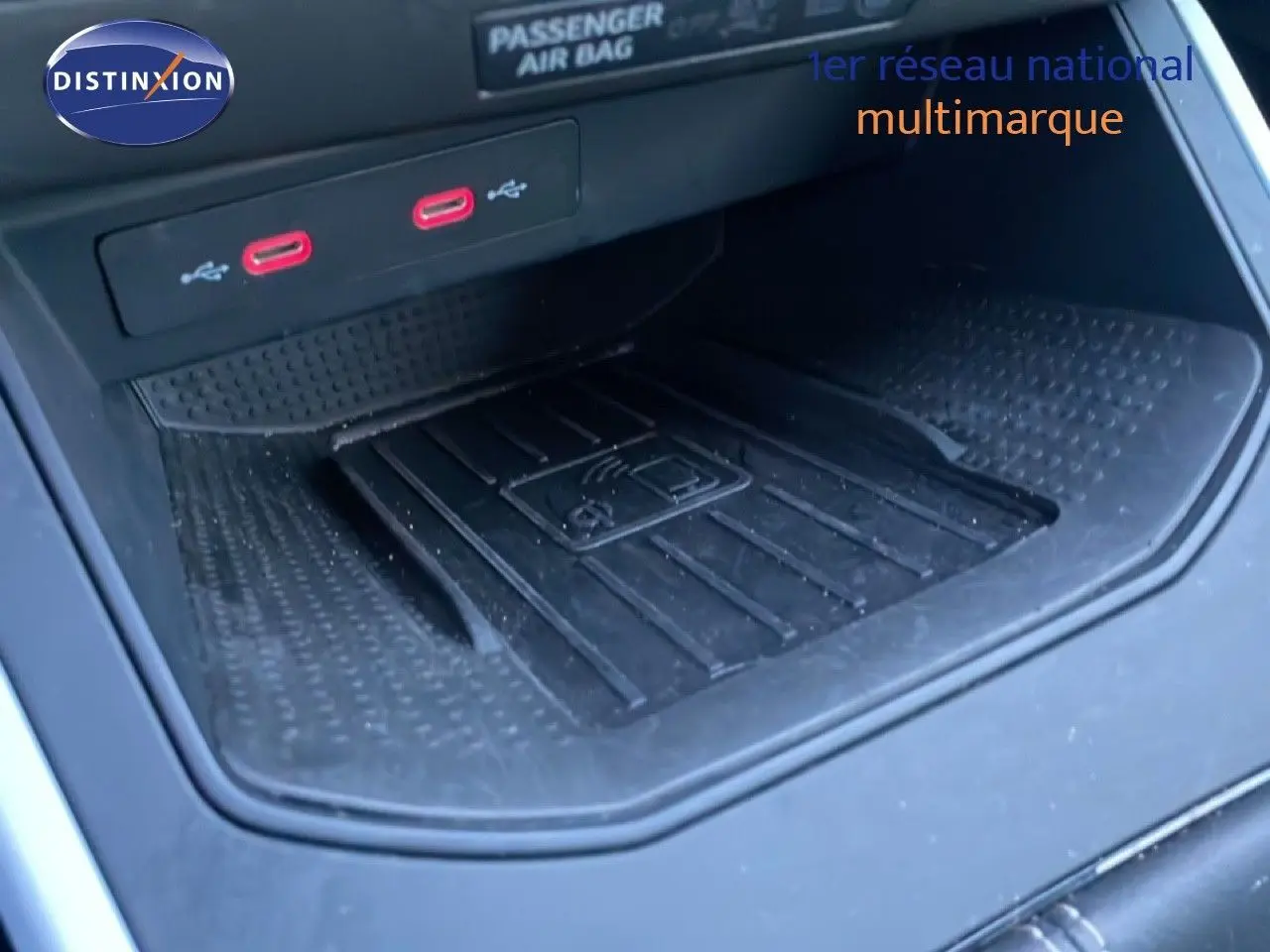 Gros plan sur la console centrale du SEAT Arona 2025, montrant un espace de recharge sans fil et deux ports USB rouges.
