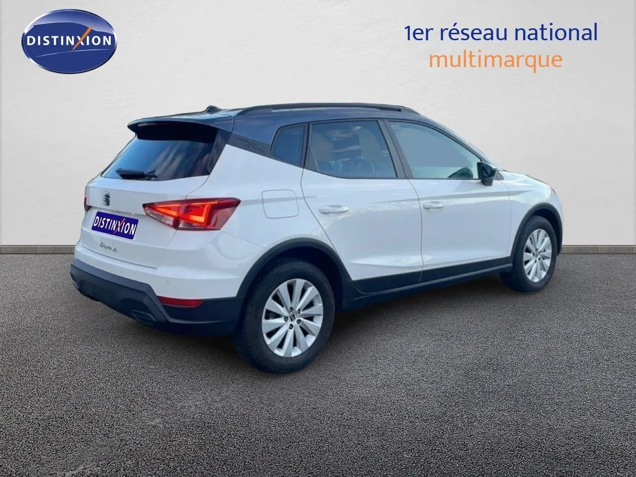 SEAT Arona blanc avec toit gris, vue 3/4 arrière côté droit, jantes alliage et feux arrière LED.