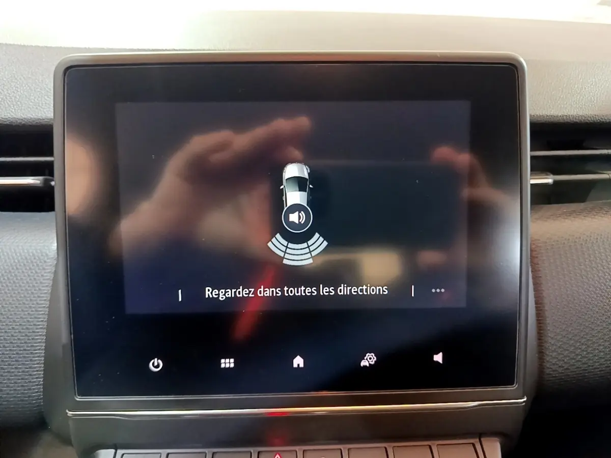 Écran tactile central de la Renault Clio Business blanc, affichant l'alerte de capteurs de proximité en vue intérieure.