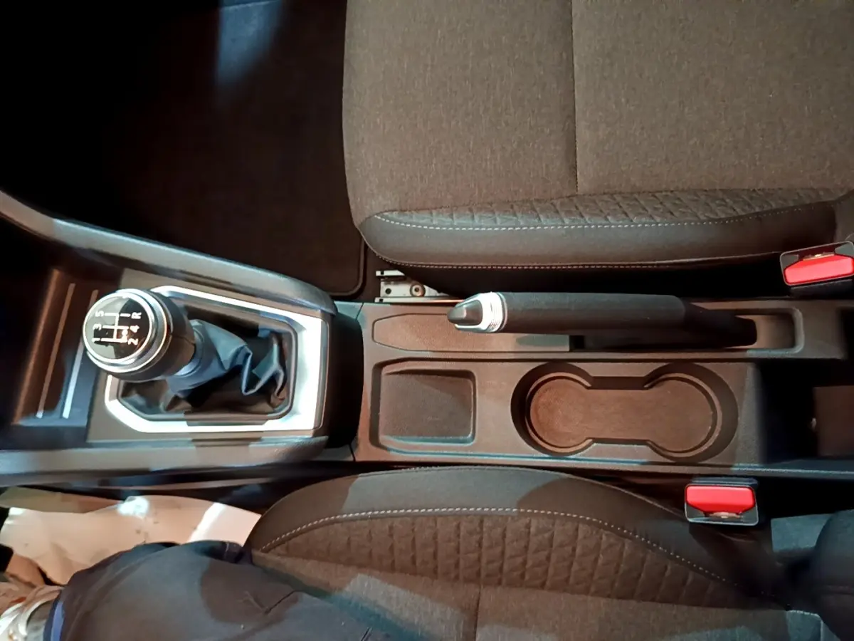 Vue plongeante sur la console centrale de la Renault Clio Business blanche, avec levier de vitesse manuel et frein à main.