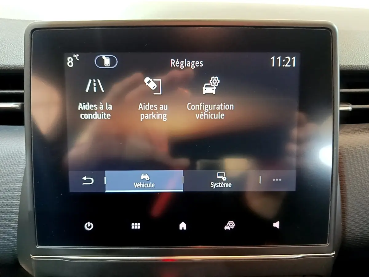 Écran tactile central de la Renault Clio Business blanc, affichant les réglages d’aides à la conduite et parking.