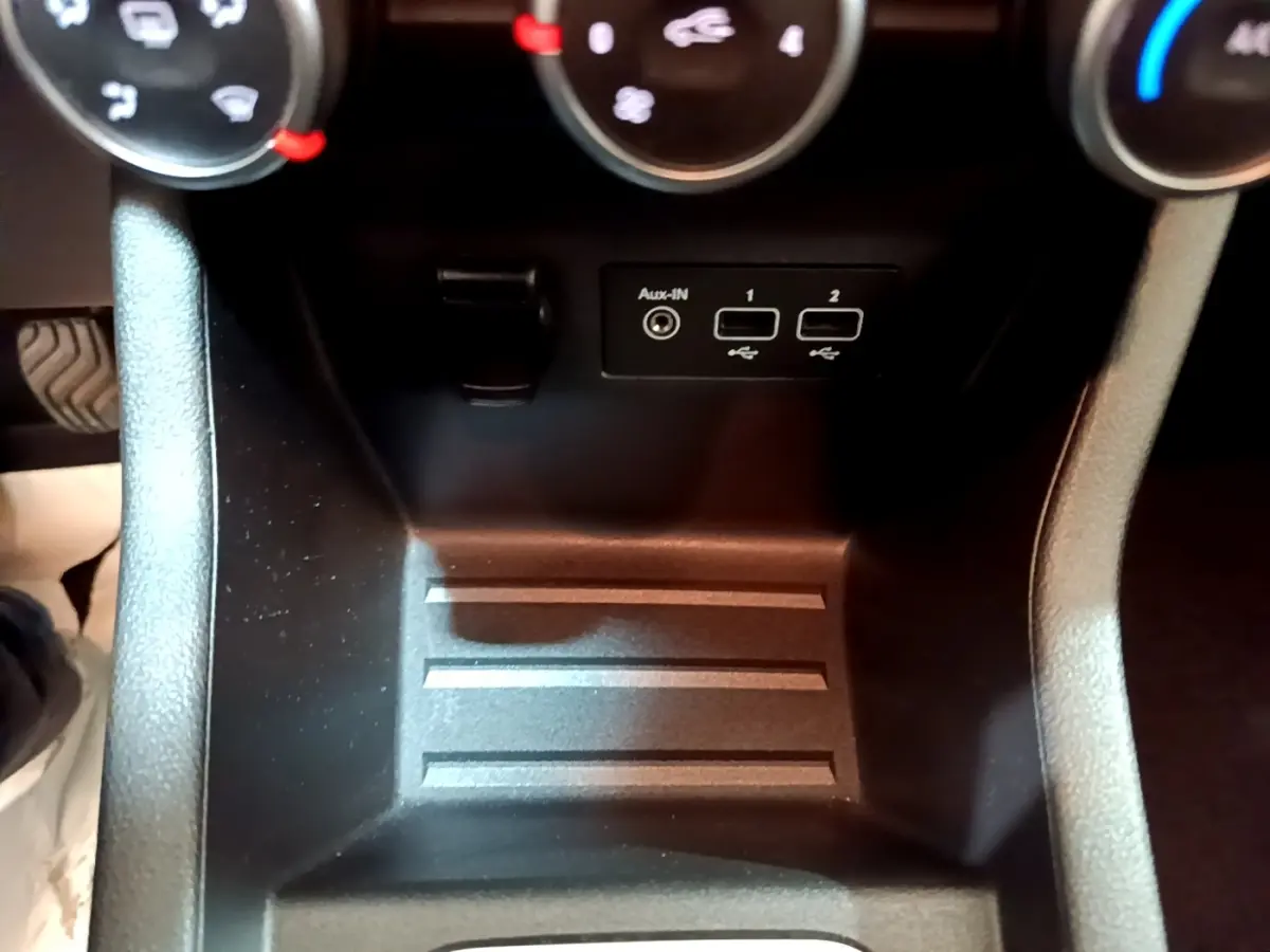 Gros plan sur la console centrale noire de la Renault Clio Business avec ports USB et entrée Aux-In sous les commandes de climatisation.