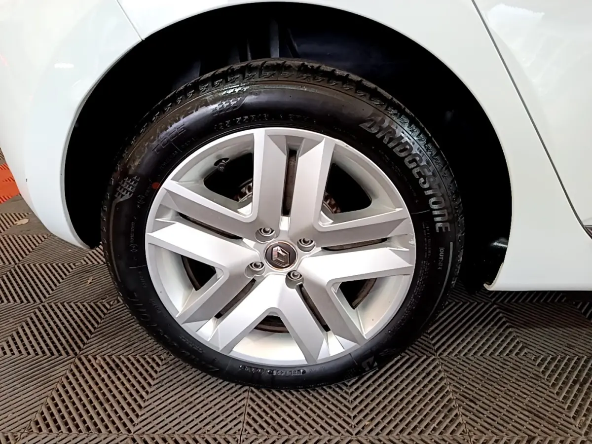 Gros plan sur la roue arrière droite blanche d'une Renault Clio Business 2021 avec pneu Bridgestone et jante argentée.