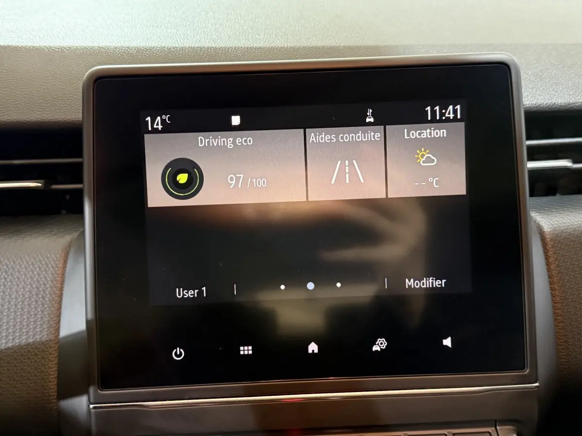 Écran tactile central du tableau de bord de la Renault Clio Business blanche, affichant les aides à la conduite.