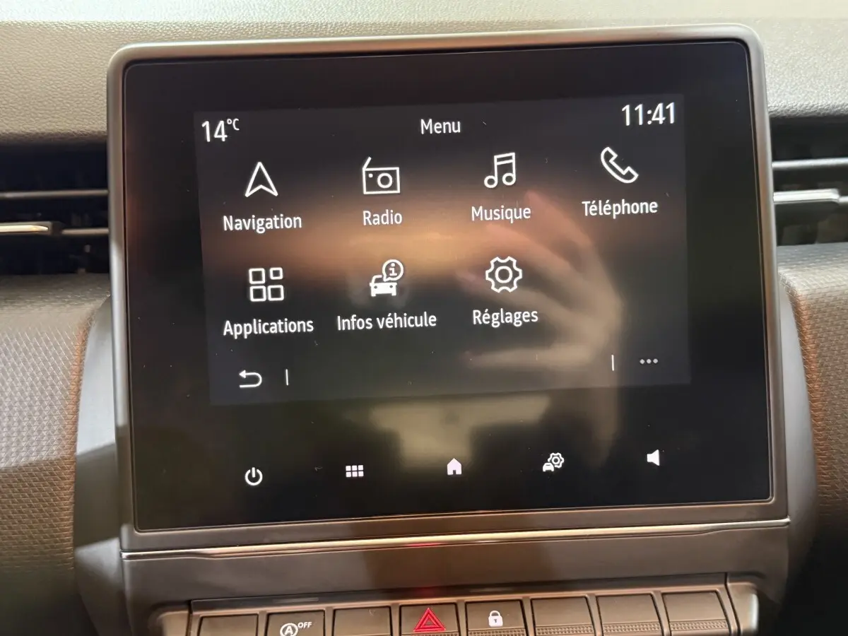 Écran tactile central de la Renault Clio Business blanc, affichant le menu principal avec options navigation et radio.