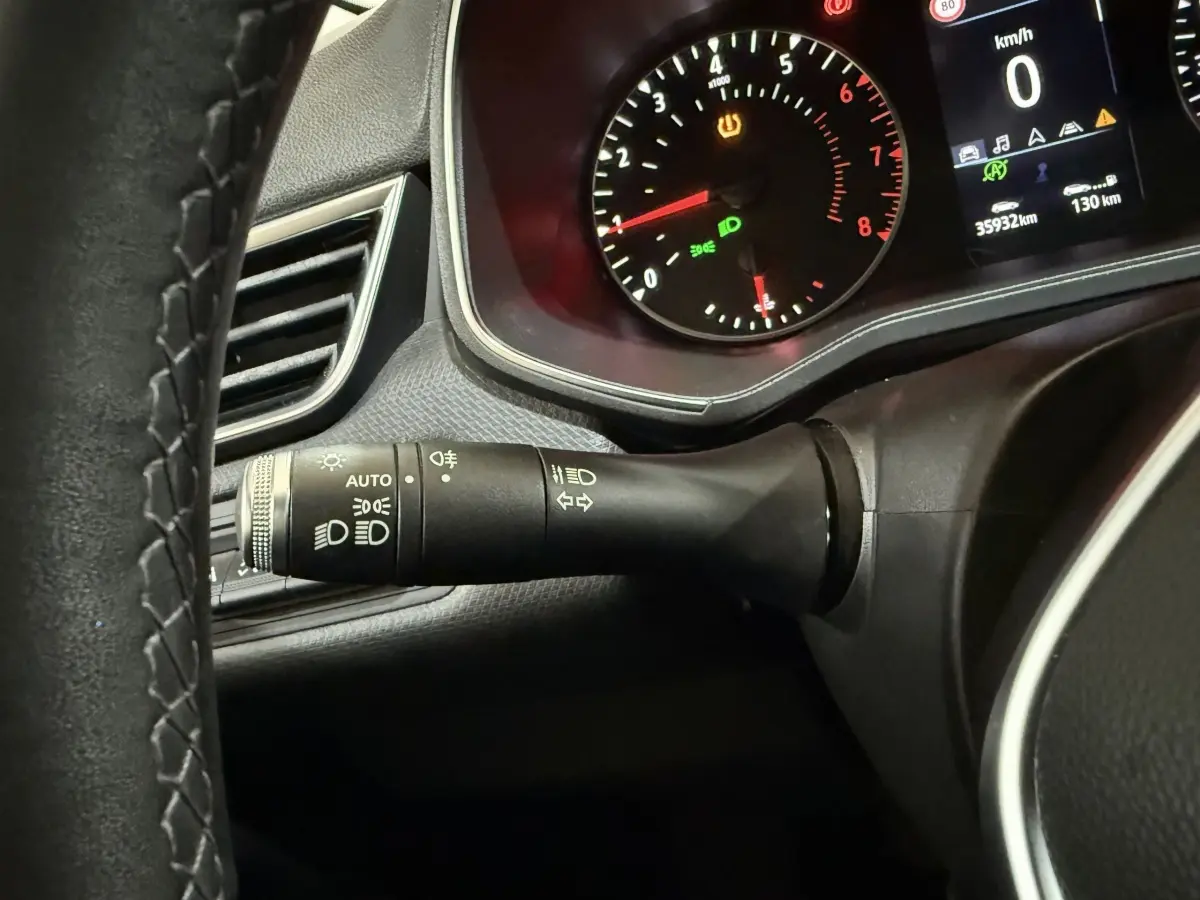 Gros plan sur le commodo d'éclairage et le tableau de bord numérique d'une Renault Clio Business blanche, 2020.