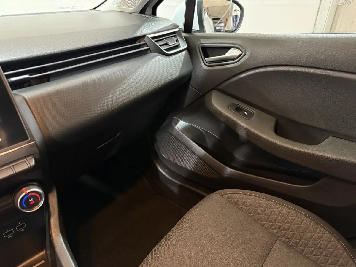 Intérieur côté passager de la Renault Clio Business 2020, avec tableau de bord noir et siège tissu gris.