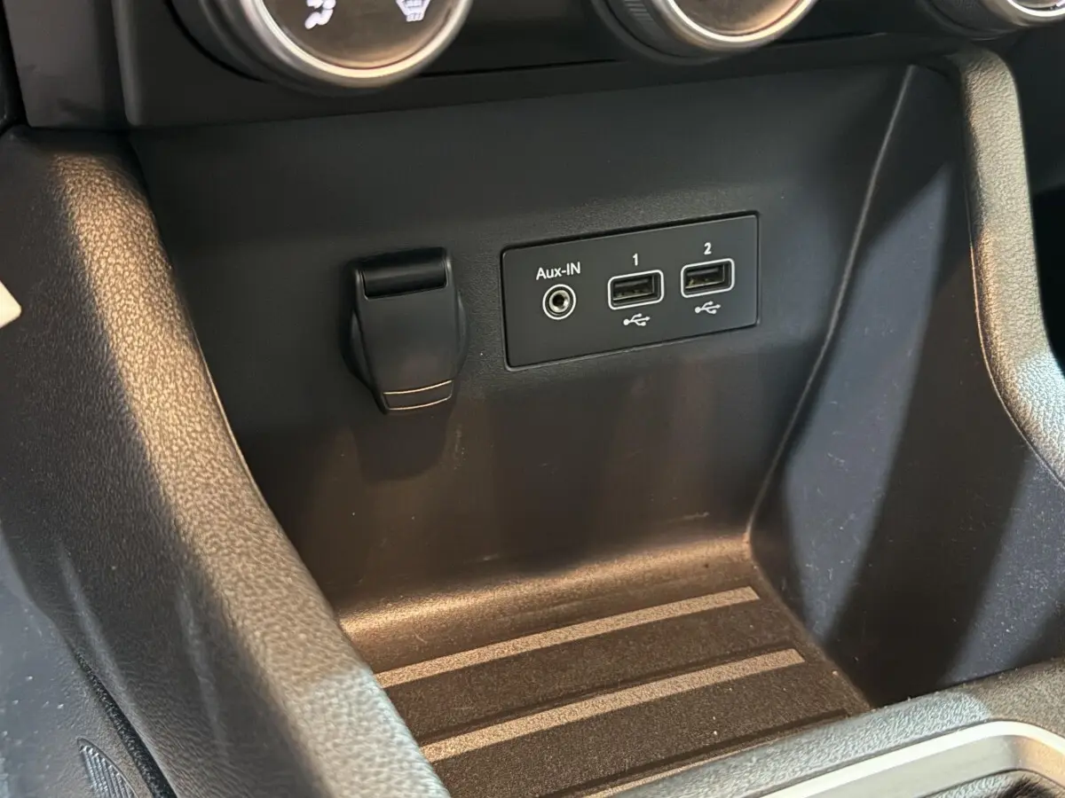 Gros plan sur la console centrale noire de la Renault Clio Business avec ports USB et prise Aux-In visibles.