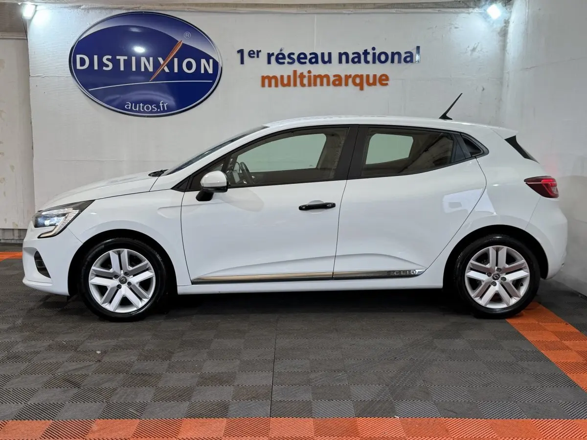 Profil droit d'une Renault Clio Business blanche 2020 avec jantes alliage et antenne de toit visible.