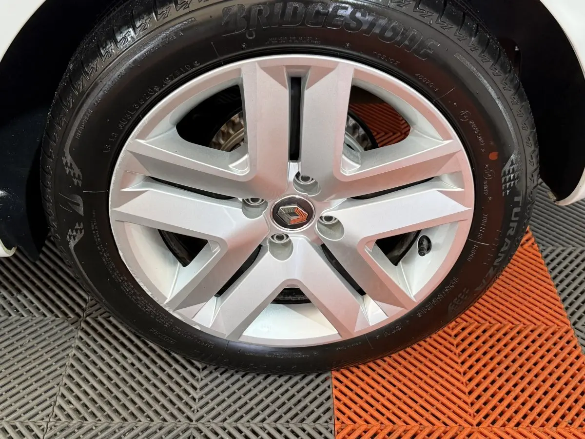 Gros plan sur la roue avant droite d'une Renault Clio Business blanche, jante alliage à cinq branches.