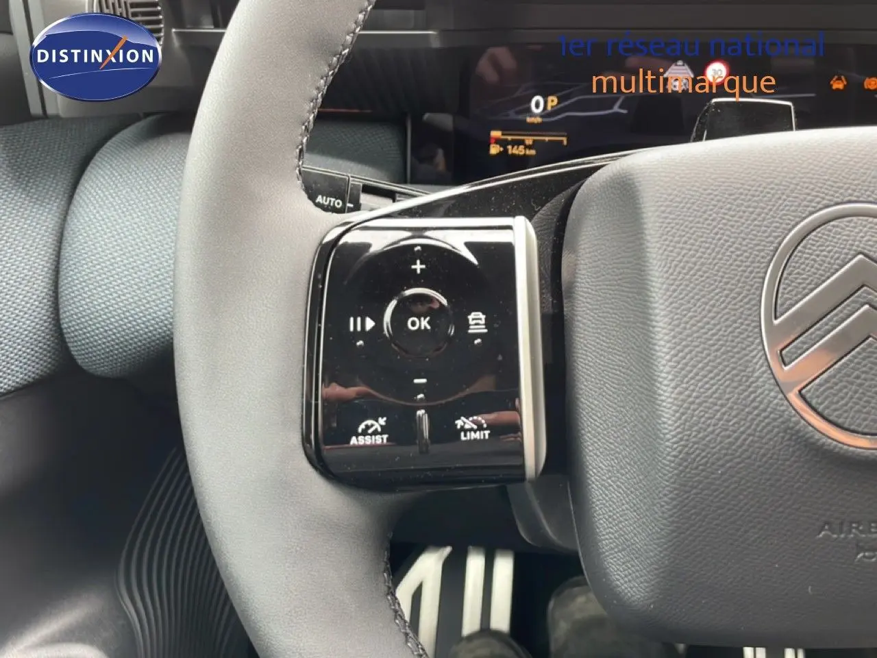 Gros plan sur le volant gris noir du Citroën C5 Aircross 2026, avec commandes intégrées et logo Citroën visible.