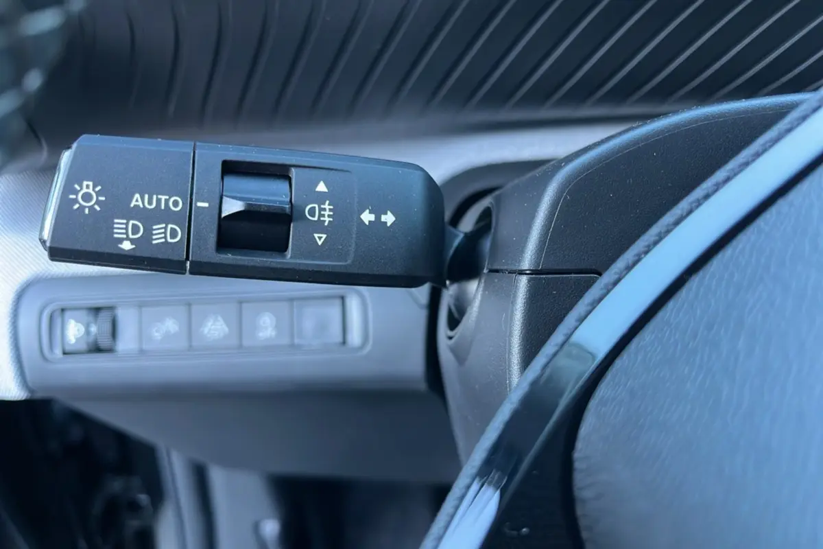 Gros plan sur la commande des feux et clignotants à gauche du volant d’un Citroën C3 Aircross noir perla nera.