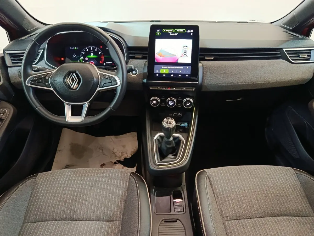 Vue intérieure frontale de la Renault Clio Techno TCe 90 2024, montrant le volant, écran tactile vertical et levier de vitesse manuel.