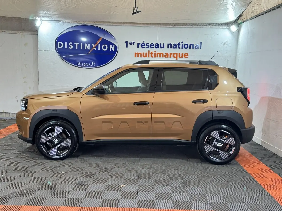 Vue de profil côté gauche d'une FIAT Grande Panda marron avec logo PANDA embossé sur la porte, roues noires distinctives.