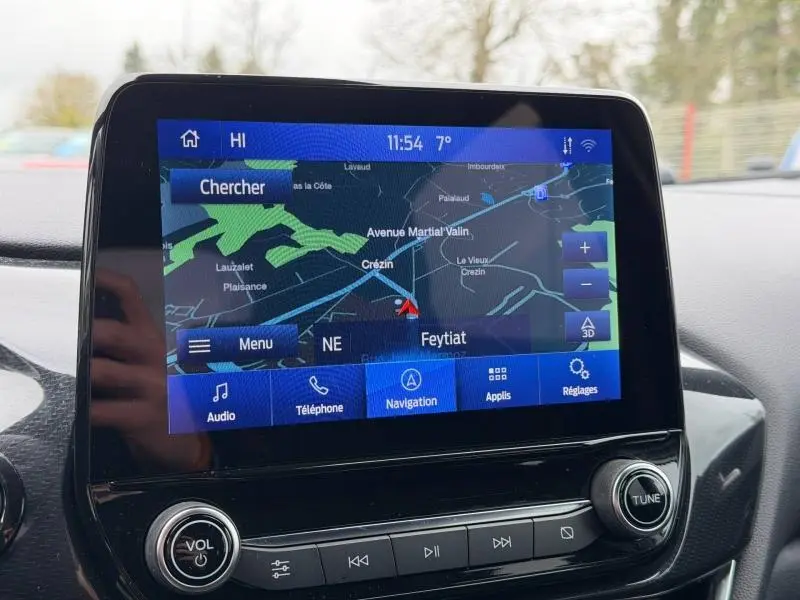 Écran tactile central du système de navigation du Ford Puma 2024, affichant une carte avec options audio et téléphone.