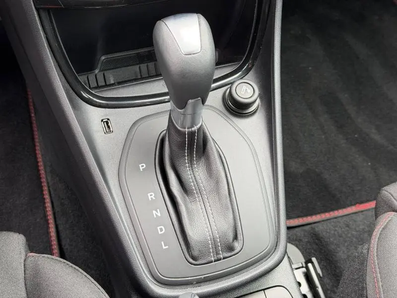 Gros plan sur le levier de vitesse automatique noir avec coutures blanches dans le Ford Puma gris Solar 2024.
