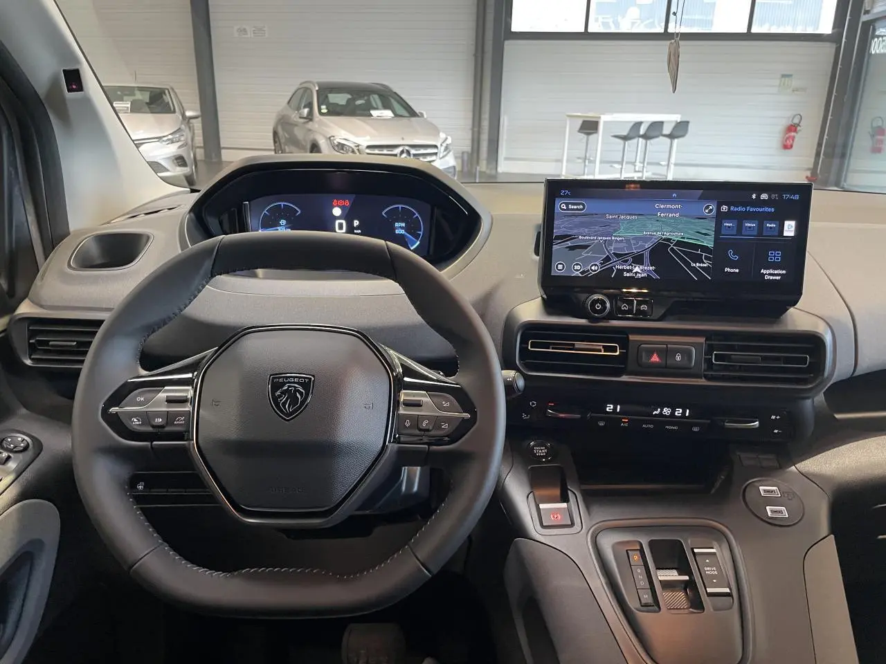 Vue intérieure du poste de conduite du Peugeot Rifter gris Artense, avec volant multifonction et écran tactile central.