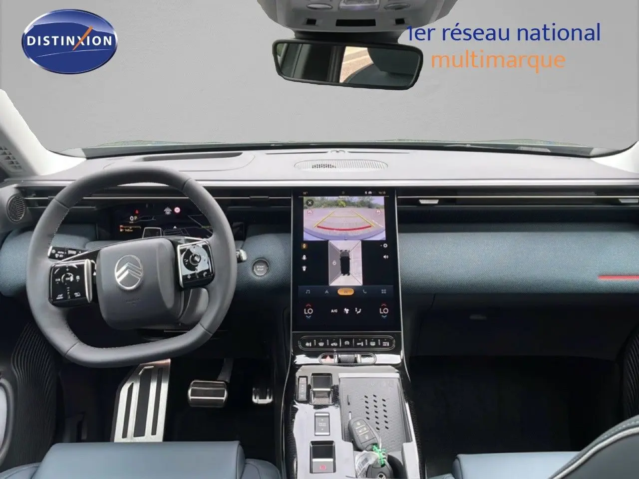 Vue intérieure avant du Citroën C5 Aircross 2026, tableau de bord et volant noir avec écran central tactile allumé.