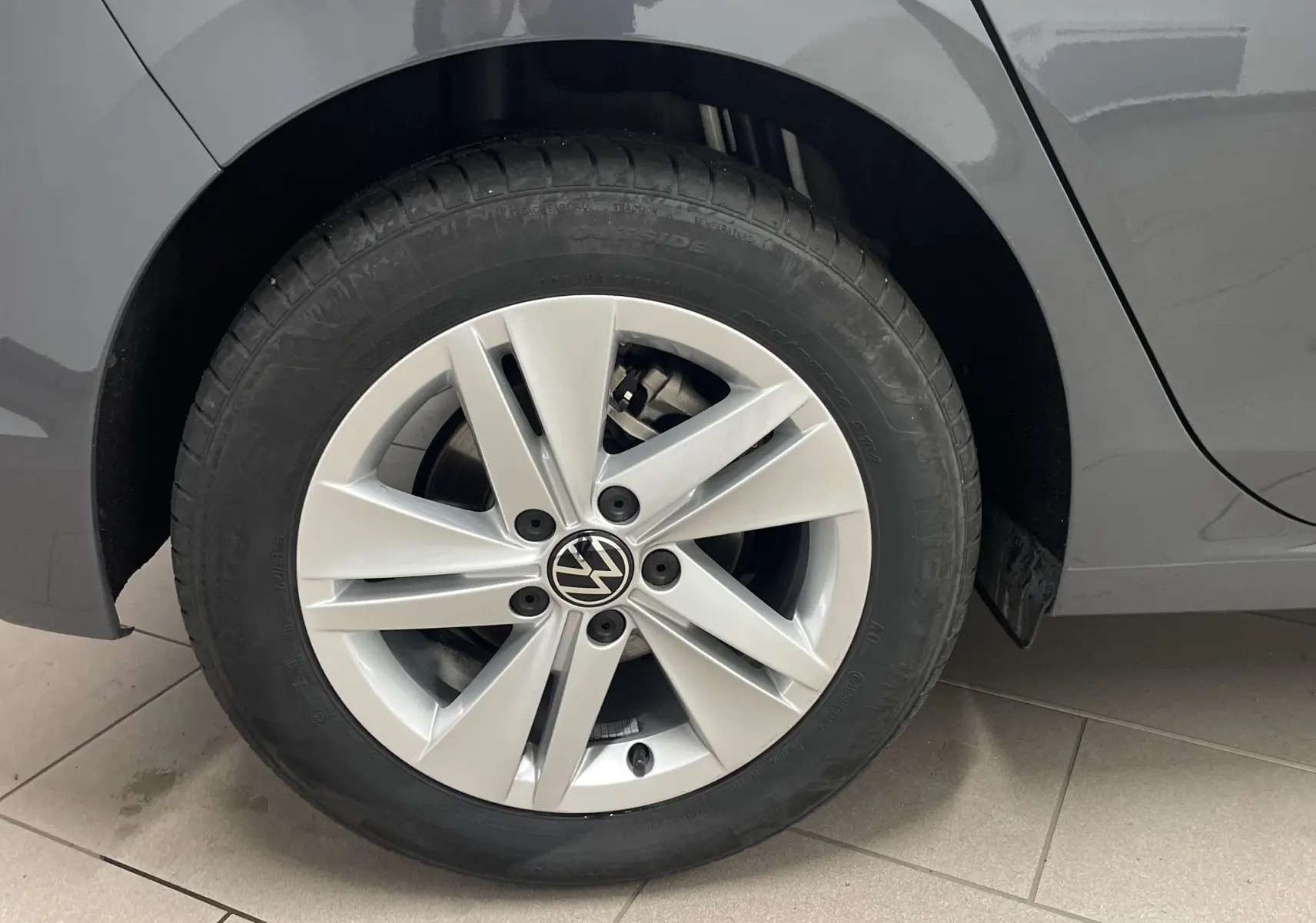 Gros plan sur la roue avant gauche de la Volkswagen Golf 1.5 TSI Gris Dauphin avec jante alliage 5 branches.