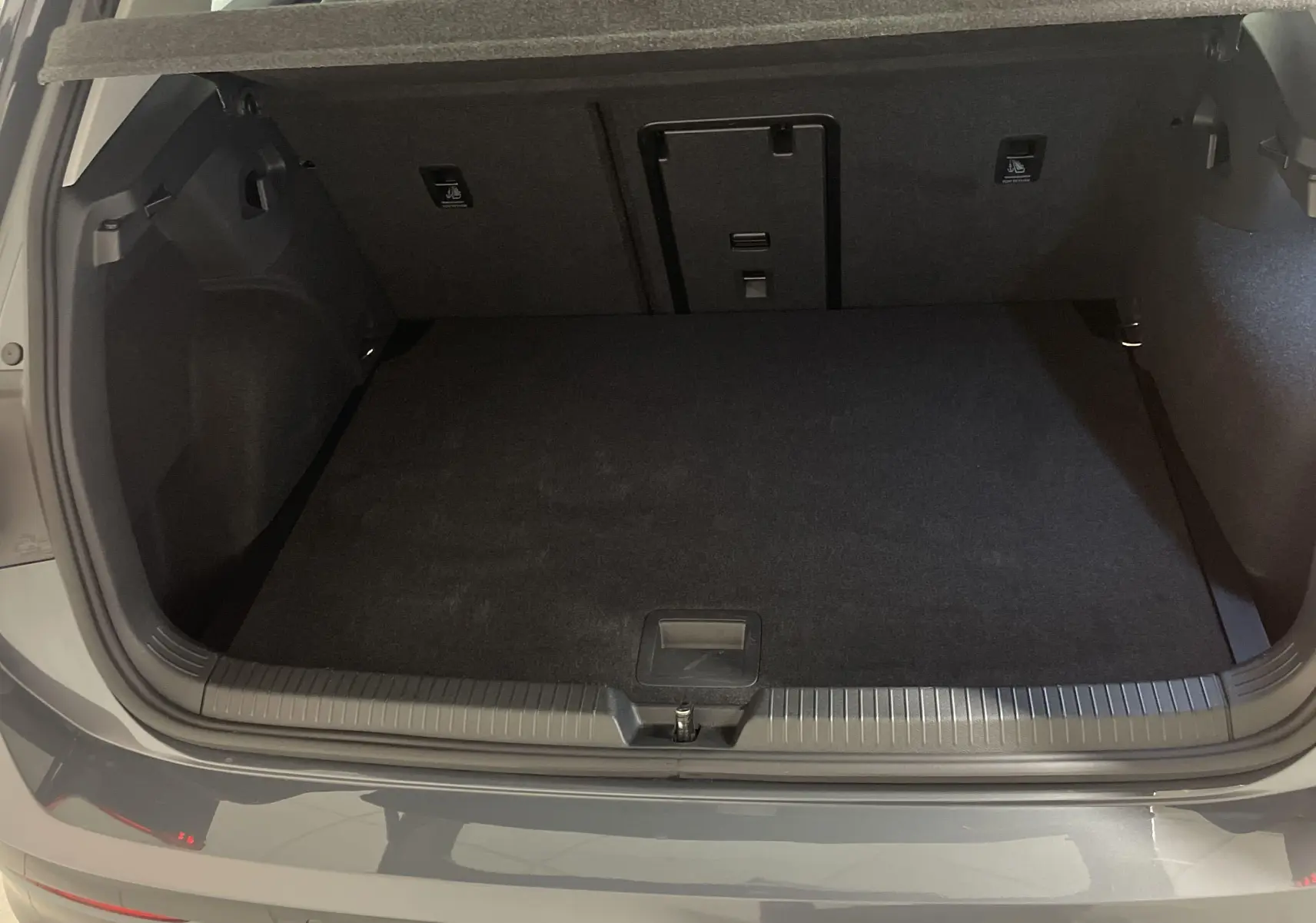 Coffre ouvert vu de l'arrière d'une Volkswagen Golf 1.5 TSI Gris Dauphin avec intérieur noir et hayon métallique.