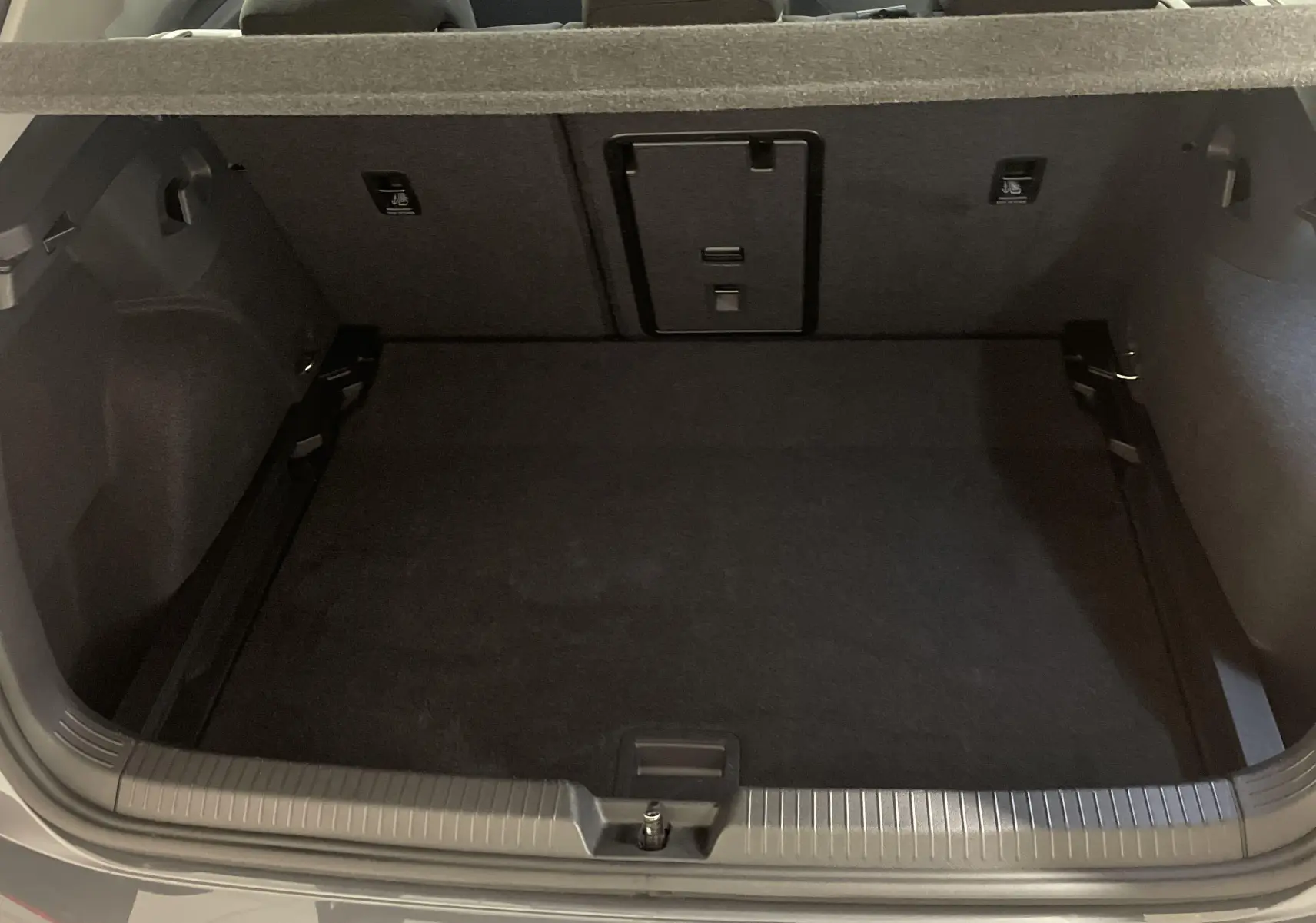 Coffre ouvert d'une Volkswagen Golf 1.5 TSI Gris Dauphin, vue arrière montrant l'espace de chargement vide.