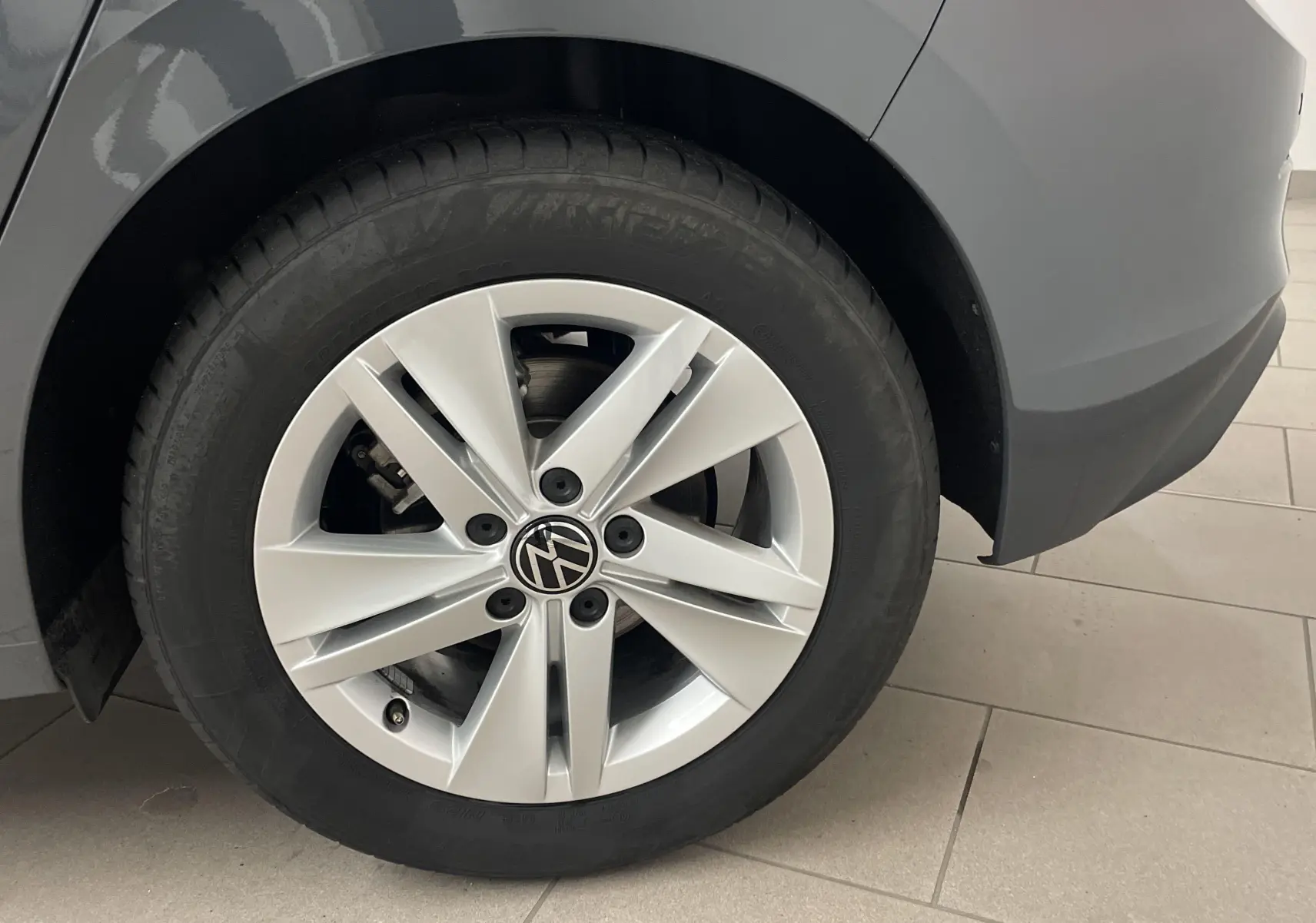 Gros plan sur la roue arrière droite d'une Volkswagen Golf 1.5 TSI 116 BVM6 gris dauphin avec jante alliage.