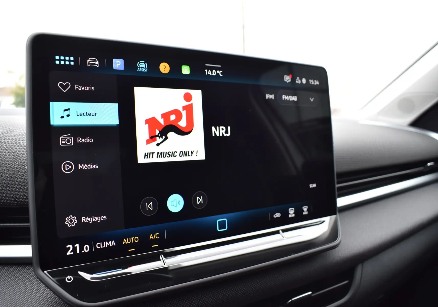 Écran tactile central du Volkswagen T-Roc 2025 affichant la radio NRJ dans un intérieur noir.