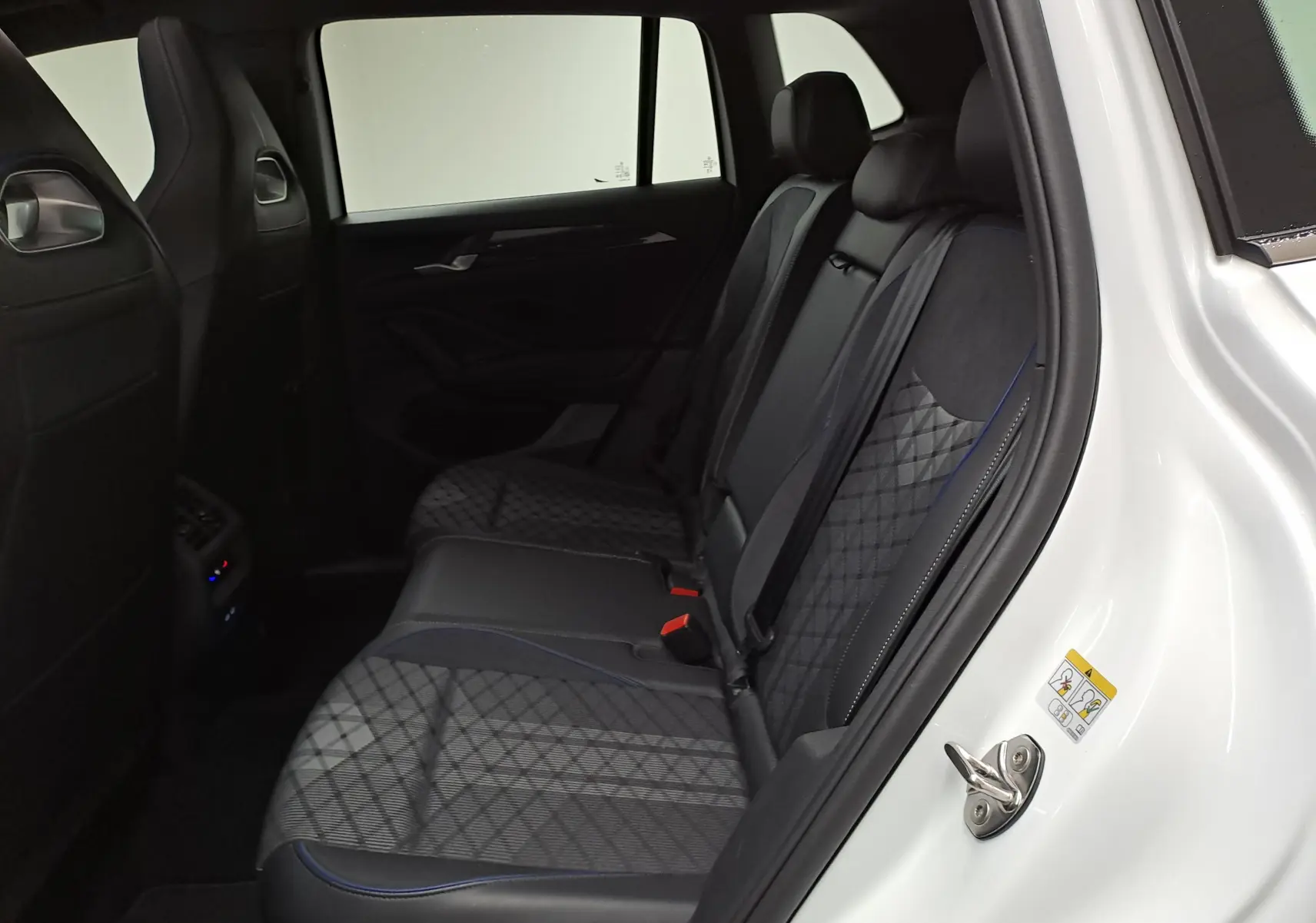 Vue intérieure côté droit sur les sièges arrière en tissu et cuir noir du Volkswagen Tiguan blanc pur 2025 R-Line Edition.