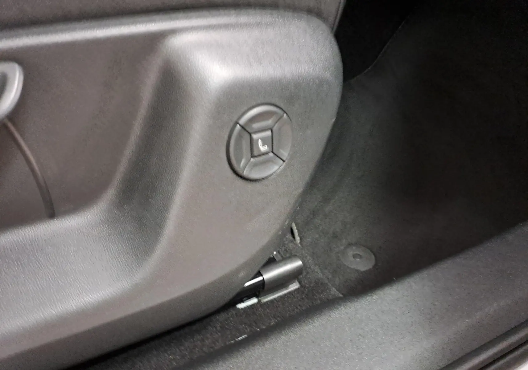 Gros plan sur le bouton de réglage électrique du siège côté conducteur du Volkswagen Tiguan blanc pur 2025.