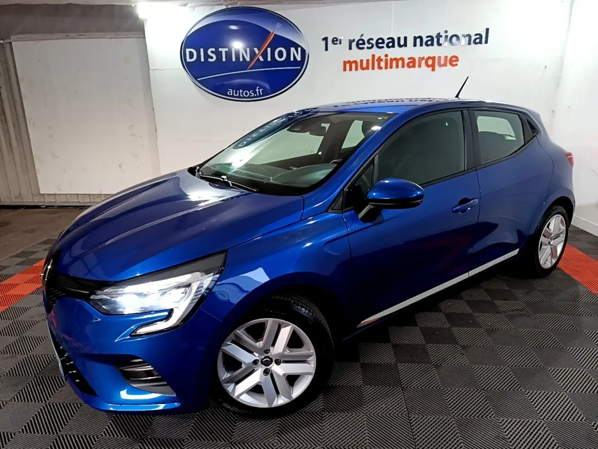 Renault Clio Business bleu vue 3/4 avant droit, phares LED allumés, jantes alliage, dans un showroom intérieur.