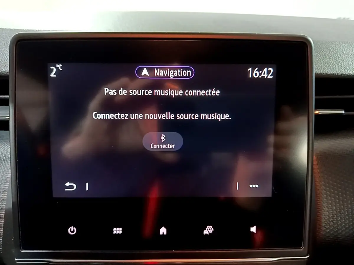 Écran tactile central de la Renault Clio Business bleu, affichant le message de connexion musique Bluetooth.