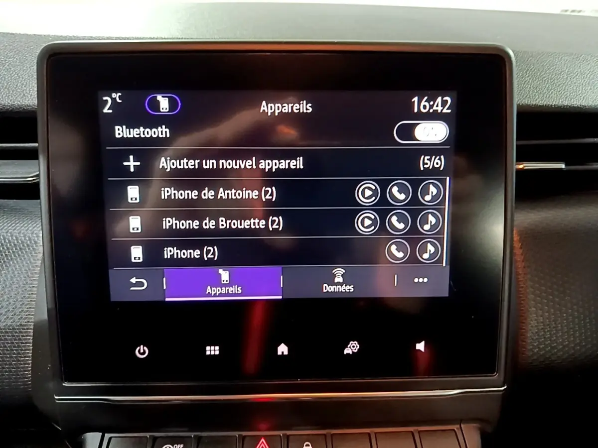 Écran tactile central de la Renault Clio Business bleu 2022 affichant le menu Bluetooth avec plusieurs appareils connectés.