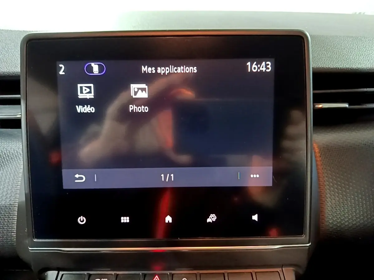 Écran tactile central du tableau de bord de la Renault Clio Business bleu, affichant le menu applications à 16h43.