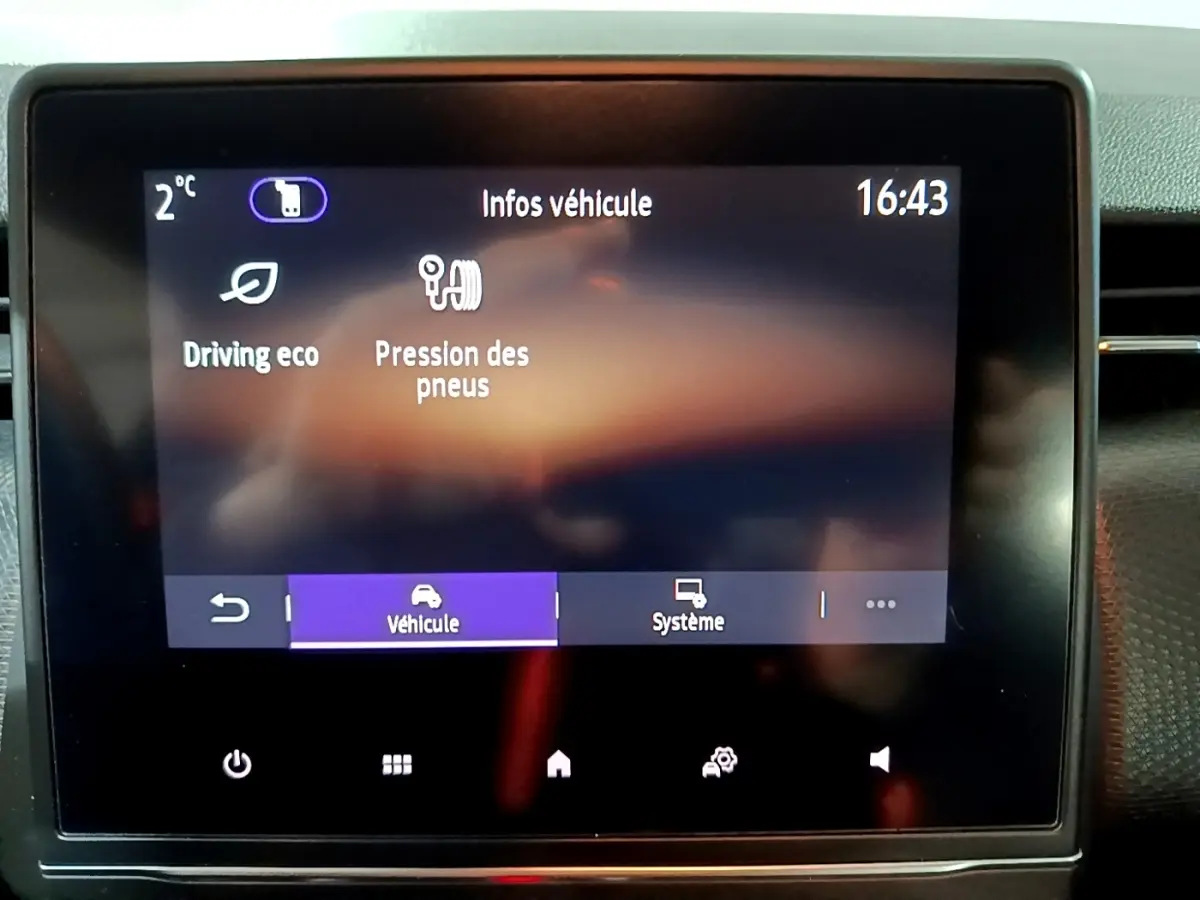 Écran tactile central de la Renault Clio Business bleu, affichant les infos véhicule à 16h43, vue de face rapprochée.