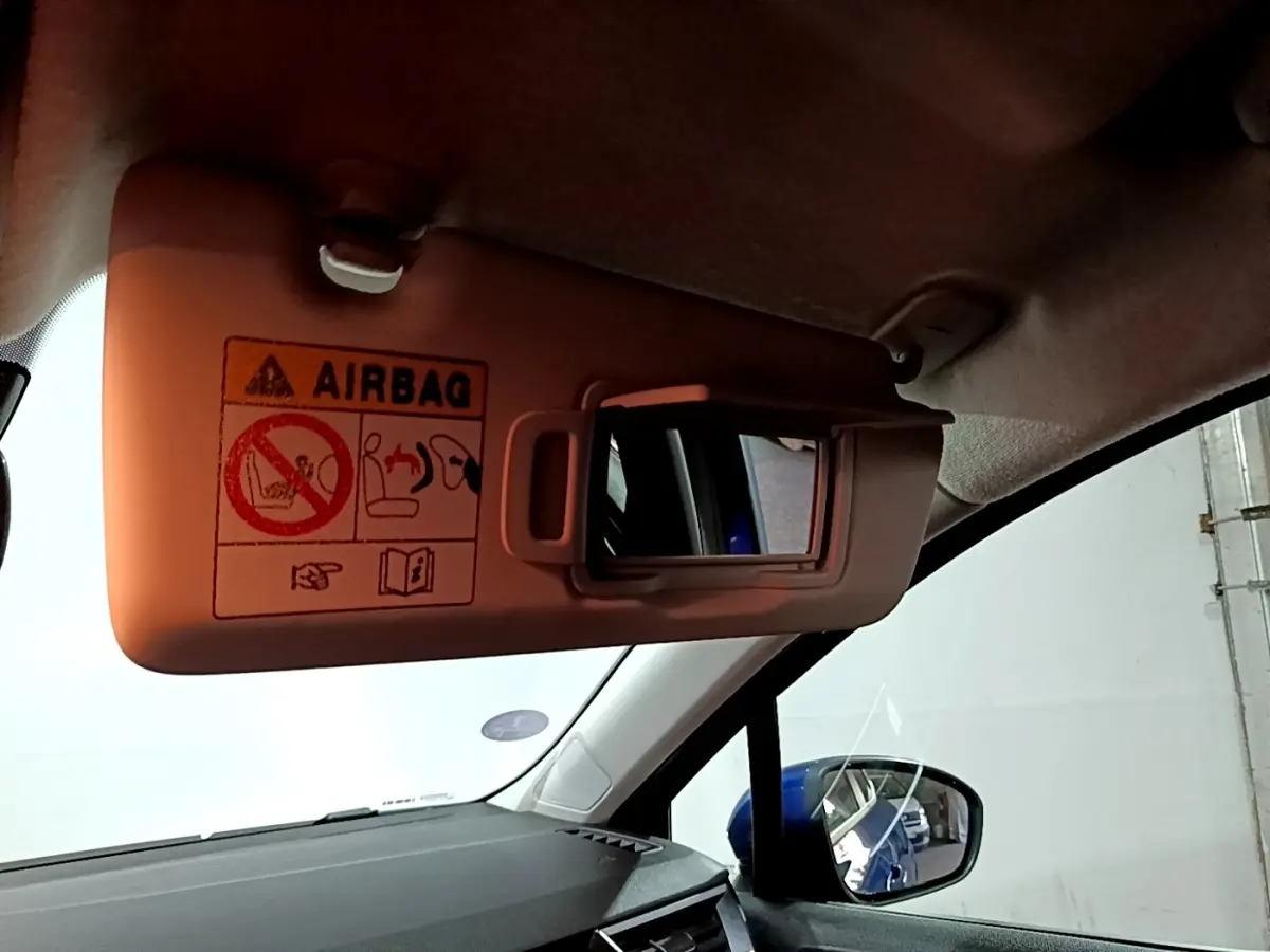 Détail du pare-soleil côté conducteur avec miroir intégré, intérieur noir et reflet bleu de la Renault Clio Business.