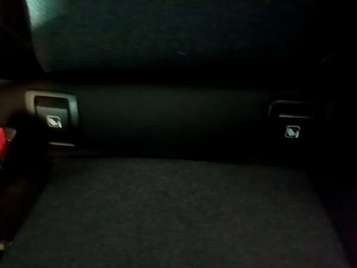 Gros plan sur la banquette arrière noire de la Renault Clio Business, montrant les leviers de rabattement des sièges.