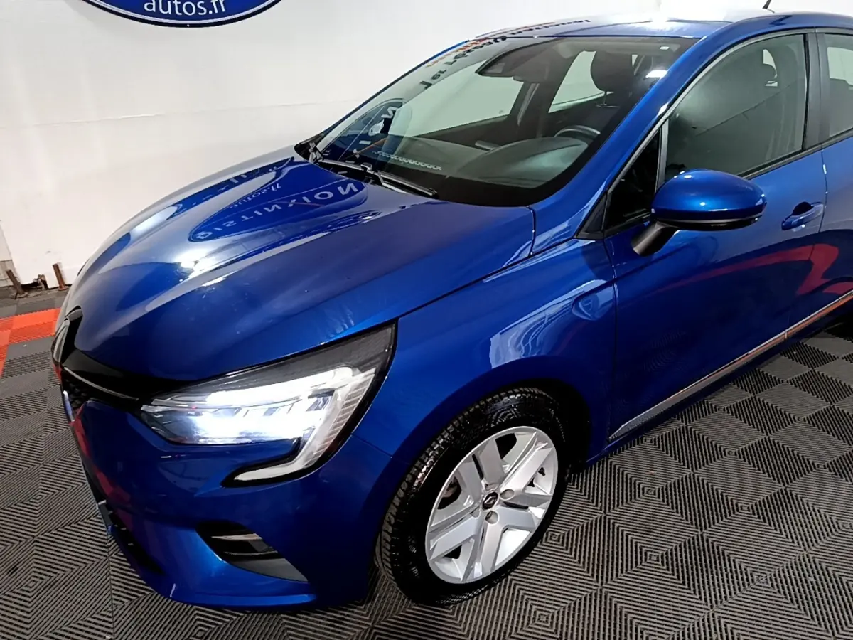 Renault Clio Business bleu vue 3/4 avant droit, phares LED allumés et jantes alliage visibles.