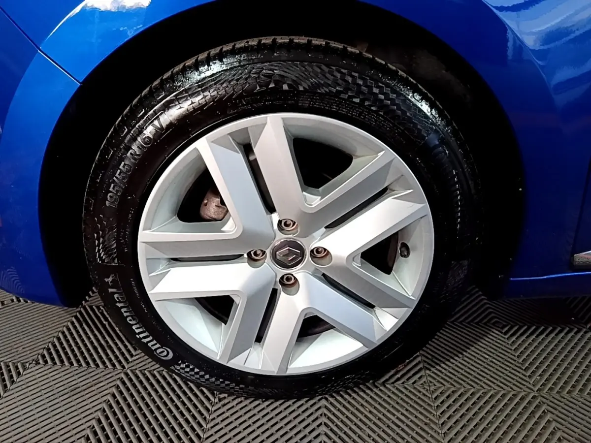 Gros plan sur la roue avant gauche avec jante alliage argentée et carrosserie bleu vif d'une Renault Clio Business 2022.