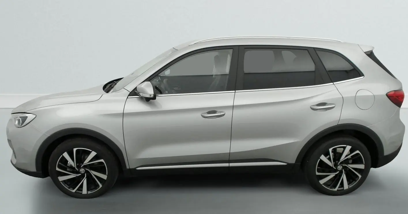 Profil côté gauche du MG ZS 1.5 L Hybrid+ gris argent, avec jantes noires et argentées distinctives.
