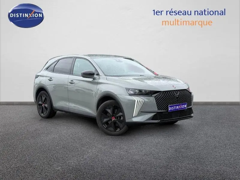 DS7 E-TENSE 225ch gris en 3/4 avant droit, avec calandre noire distinctive et jantes noires, vue extérieure sur fond neutre.