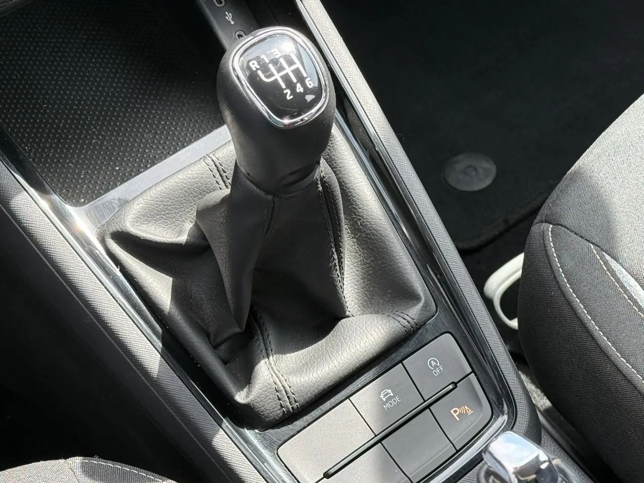 Le levier de vitesse manuel noir de la Skoda Scala TSI 116, avec console centrale et siège partiel gris.