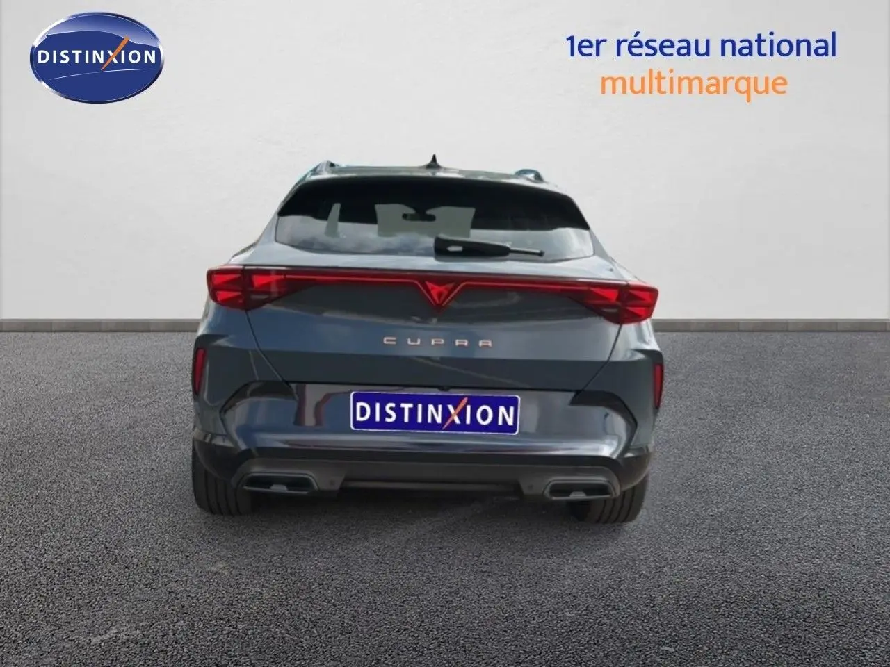 Vue arrière d'une CUPRA Formentor gris magnétique métal avec feux LED reliés et double sortie d'échappement.